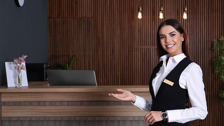 Rezeptionistin lädt zum Nähertreten ein