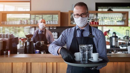 In der Gastronomie soll eine Ausnahme der Maskenpflicht herrschen, wenn man einen negativen Corona-Test vorzeigt. (Foto: © .shock – stock.adobe.com)
Servicekraft mit Maske und vollem Tablet
