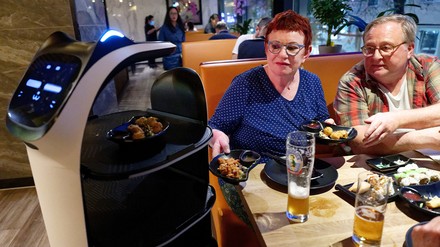 Gäste nehmen im Sushi-Restaurant „Nakoyashi“ ihre bestellten Speisen aus dem Serviceroboter Miaomiao. (Foto: © picture alliance/dpa | Henning Kaiser)
Serviceroboter Miaomiao