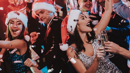 Tanzen bis der Arzt kommt? Solange der Chef die Weihnachtsfeier noch nicht offiziell beendet hat, kein Problem. Erst, wenn er sich verabschiedet, erlischt der Versicherungsschutz des Arbeitgebers. (Foto: © VadimGuzhva/Stock.adobe.com)
Tanzende Leute bei einer Weihnachtsfeier.