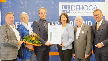 Übergabe des Zertifikats (v.l.n.r.): Friedhelm Münch, Beigeordneter des Kreises Ahrweiler; Susanne Weiss, Geschäftsführender Vorstand Ringhotels, Michael Vierjahn, geschäftsführender Hoteldirektor Ringhotel Haus Oberwinter; Daniela Schmitt, Wirtschaftsministerin von Rheinland-Pfalz; Rudi Frick, Beigeordneter der Kreisstadt Bad Neuenahr-Ahrweiler;
Gereon Haumann, DEHOGA Präsident Rheinland-Pfalz. (Foto: © Ringhotels e.V.)
Michael Vierjahn, geschäftsführender Hoteldirektor Ringhotel Haus Oberwinter nimmt die Auszeichnung von Wirtschaftsministerin Daniela Schmitt entgegen.