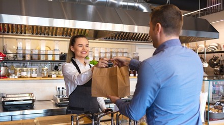 Ab 2023 werden gastronomische Betriebe dazu verpflichtet, neben Einweg- auch Mehrwegbehälter für Essen und Getränke zum Mitnehmen anzubieten. (Foto: © DanRentea/stock.adobe.com)
Essensübergabe in einem Restaurant