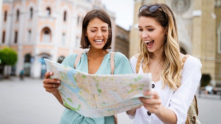 Auch in den aktuell wirtschaftlich schwierigen Zeiten wollen die Deutschen verreisen. (Foto: © NDABCREATIVITY/stock.adobe.com)
Zwei Frauen mit Stadtplan