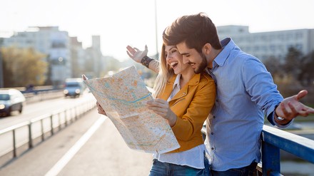 Die Tourismusbranche in Deutschland hat sich im Jahr 2022 teilweise von der Corona-Krise erholt. (Foto: © NDABCREATIVITY/stock.adobe.com)
Glückliche Touristen mit einer Karte in mitten in der Stadt