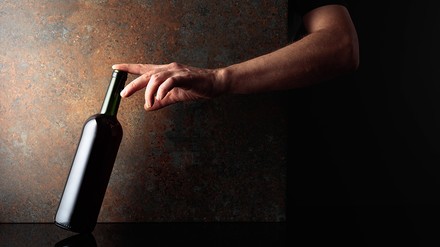 Wein-Diebe verurteilt. Von den erbeuteten Weinen fehlt jedoch jede Spur. (Foto: © Igor Normann/stock.adobe.com)
Eine Hand greift nach einer Weinflasche.