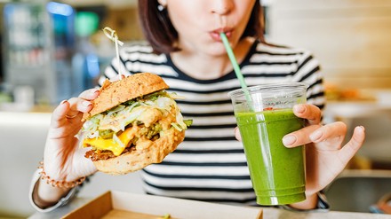 Auswärts vegan essen wird einfacher: Betriebe der Systemgastronomie können ab sofort wieder eine Lizenzierung mit dem Gütesiegel V-Label erhalten. (Foto: © EdNurg/stock.adobe.com)
Frau trinkt und isst in einem veganen Restaurant
