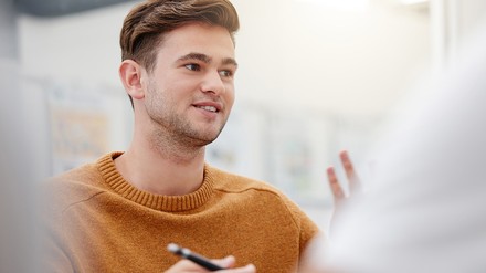 Ein junger Mann informiert sich über die Ausbildung zum Hotelfachmann. (Foto: © Siphosethu Fanti/peopleimages.com/stock.adobe.com)
Ein junger Mann im Gespräch mit einer anderen Person.