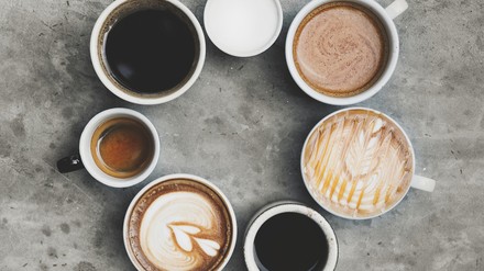 Sieben Tassen mit unterschiedlichen Kaffeegetränken, Filterkaffee, Cappuccino, Espresso