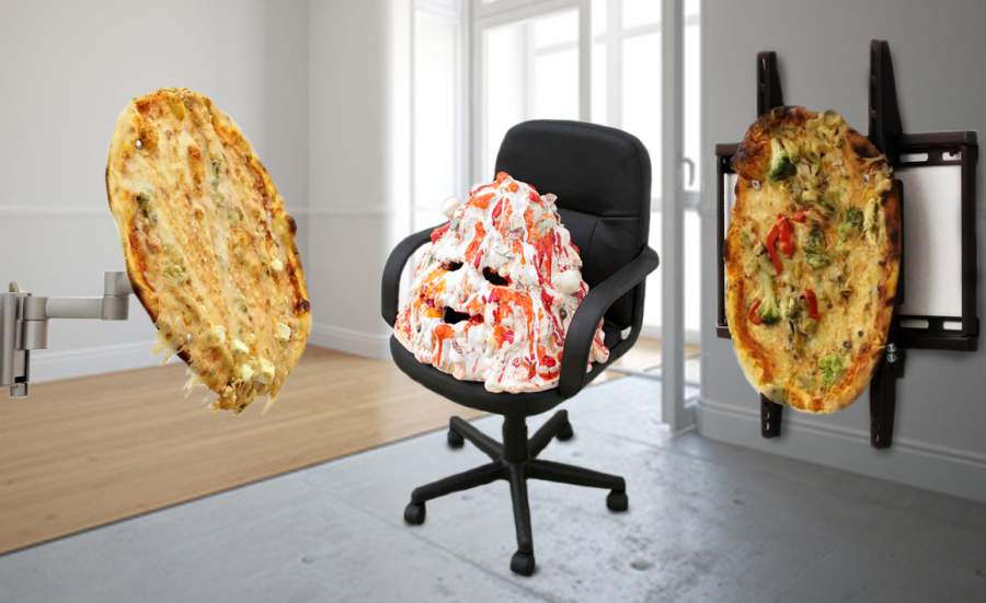 In einem Raum hängt eine Pizza an einer Fernsehhalterung, eine Pizza ist auf einem Bürostuhl platziert und scheint ein Gesicht zu haben, eine weitere Pizza ist an einer Bildschirmhalterung befestigt