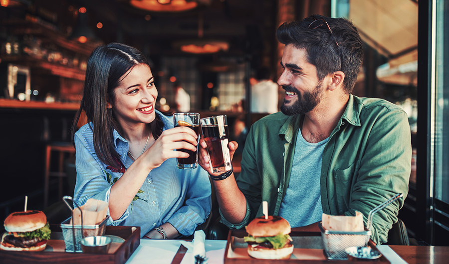 Ein Paar stößt im Restaurant mit alkoholfreien Getränken an